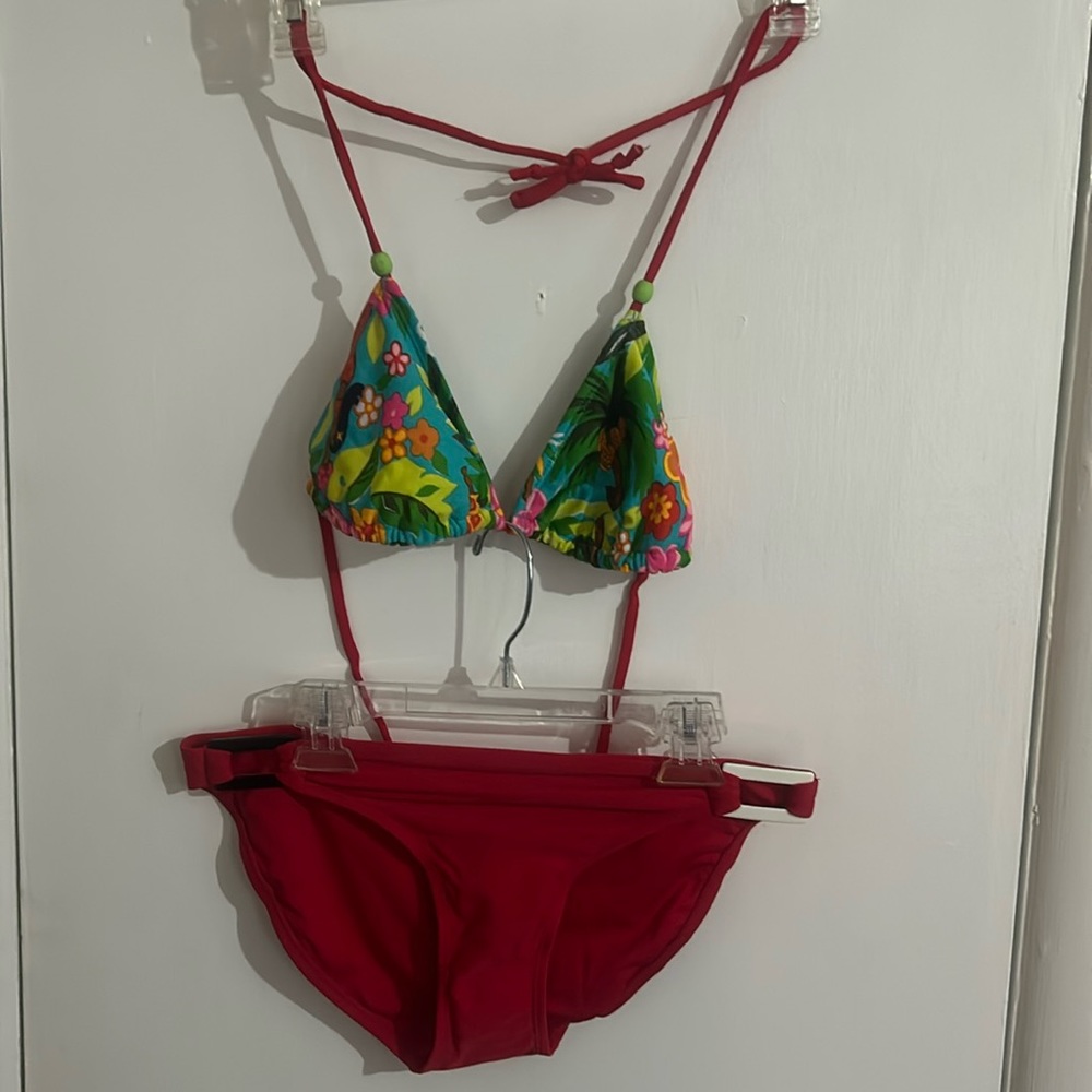 2 piece medium Hawaiian hula girl, floral plant, print top and red bottom.